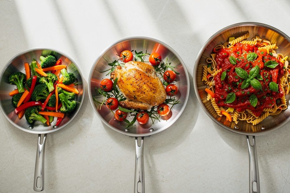 Cuisine lumineuse vue de dessus, avec trois poêles en titane de tailles croissantes posées sur un plan de travail et contenant chacune une portion d’aliments.